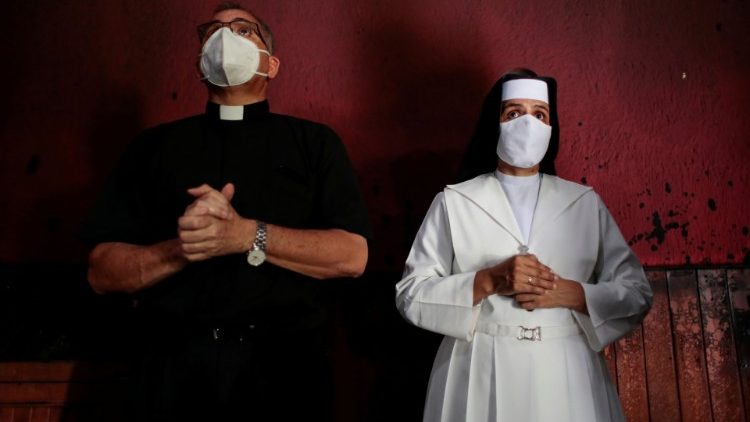 Un prêtre et une religieuse à Managua devant une image du "Sang du Christ", détruite le 31 juillet dans un incendie criminel. 