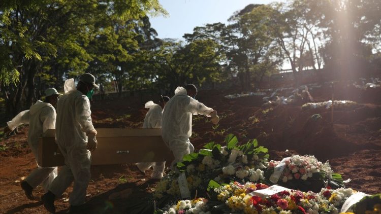 ब्राजील के सान पावलो में  कोरोना बीमारी से मृत व्यक्ति को दफनाते  हुए लोग
