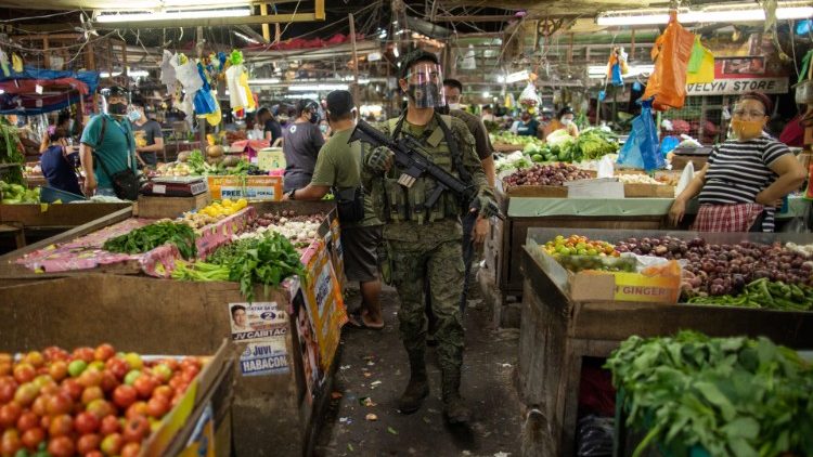 A police officer ensuring Covid-19 health protocols are being observed in a public market in the Philippines.