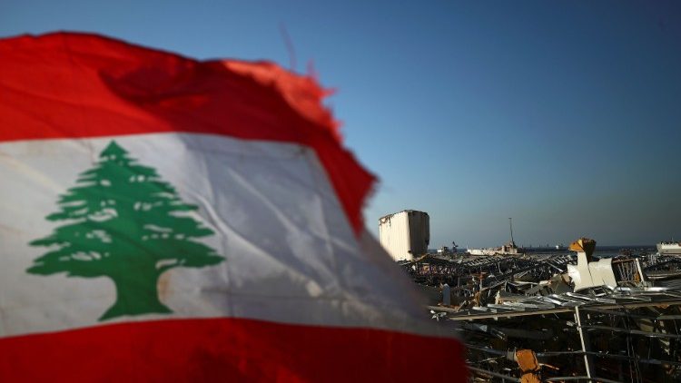 Lebanese flag is pictured, in the aftermath of a massive explosion, in Beirut's damaged port area