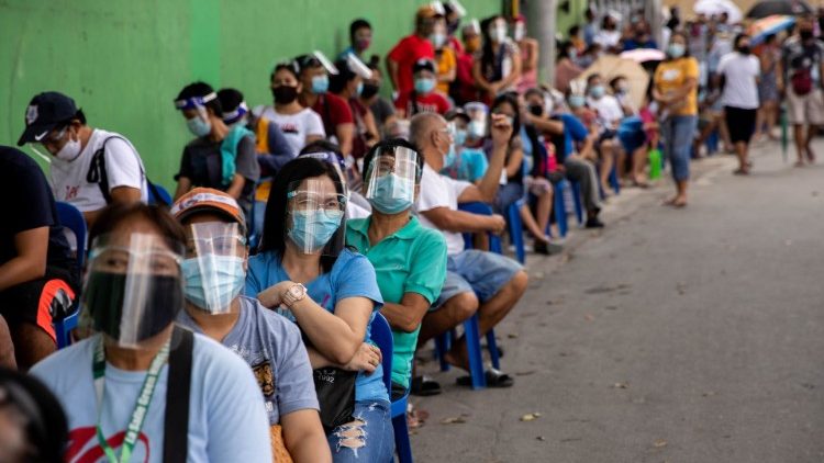 Menschen in Quezon City stehen Schlange bei der Verteilung von Hilfspaketen