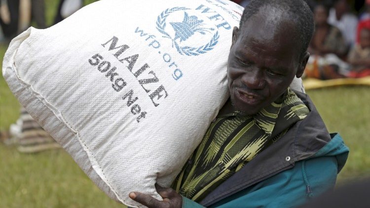 FILE PHOTO: A Malawian man carries food aid distributed by the United Nations World Food Progamme (WFP) in Mzumazii village near the capital Lilongwe