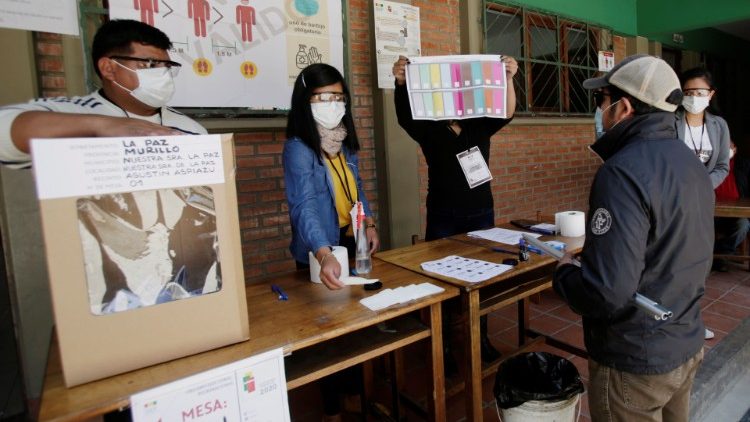 Trabajadores con máscaras de protección, durante un simulacro de votación en un centro de votación en La Paz