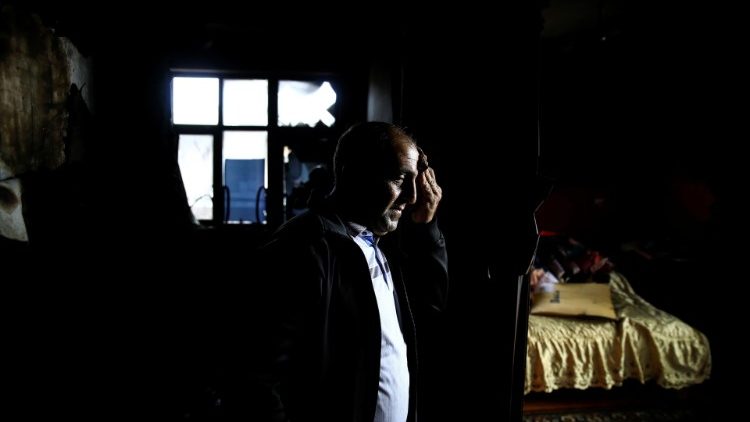 A man visits his burnt house in Terter after a ceasefire begins in Nagorno-Karabakh