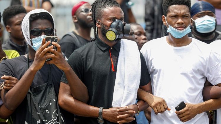 Demonstrators wearing protective masks take part in a protest over police brutality, in Lagos