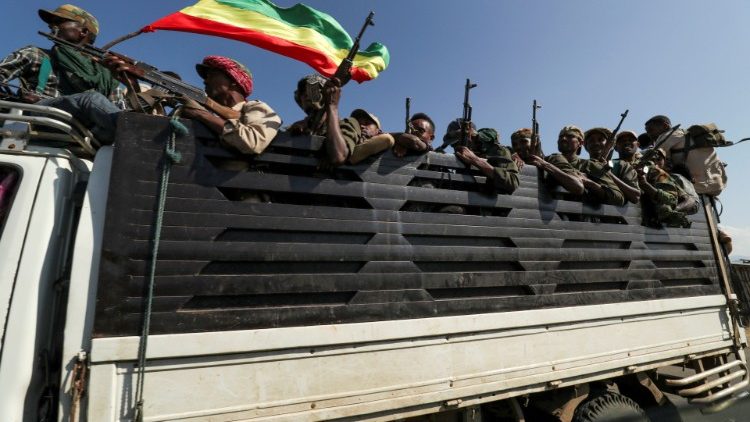 Members of Amhara region militias ride on their truck as they head to face the Tigray People's Liberation Front in Sanja
