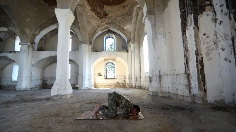 Soldado reza na mesquita em Azerbaijão