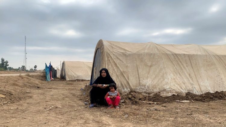פליטה עיראקית עם בנה במחנה הפליטים המאולתר שבבאלאד. 