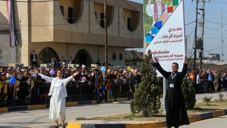 Sacerdote e religiosa animam os fiéis em rua de Qaraqosh, na iminência da visita do Papa Francisco, em 7 de março de 2021