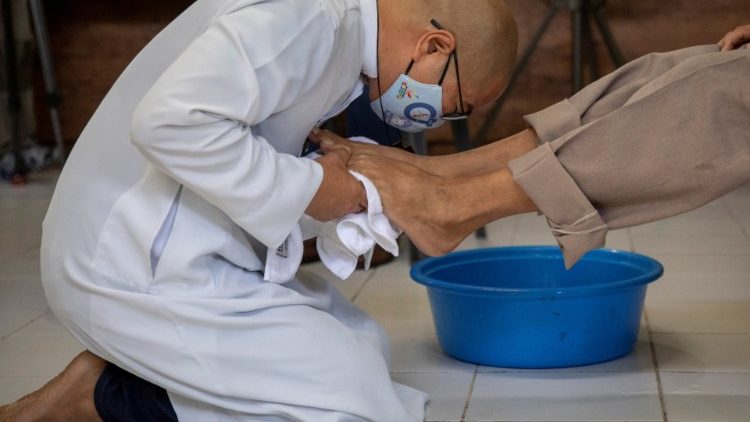 Katholischer Priester bei einer Fußwaschung für Bedürftige am Gründonnerstag in Manila