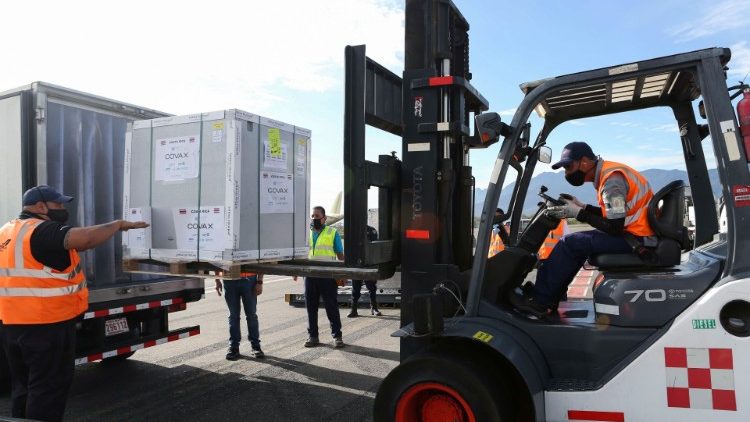 Workers load a container holding doses of Covid-19 vaccine that arrived under the COVAX scheme, in Costa Rica