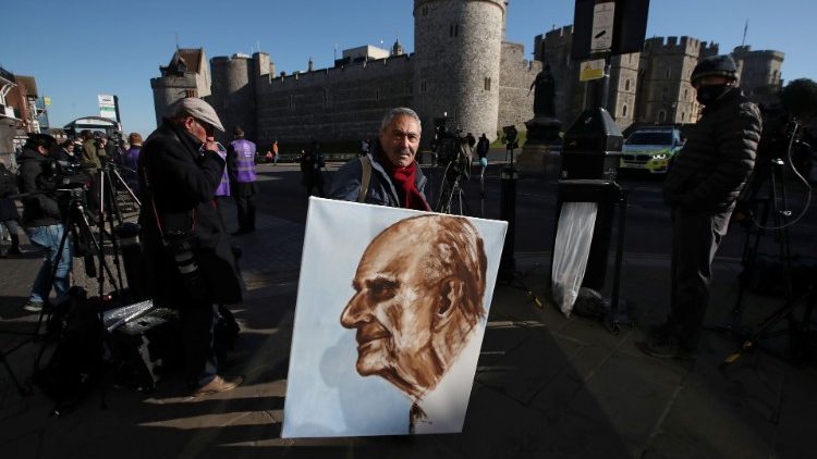 A man holds a painting of Prince Philip outside Windsor castle