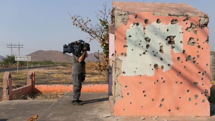 Ein Kameramann filmt eine von Kugeln durchlöcherte Kapelle in El Aguaje
