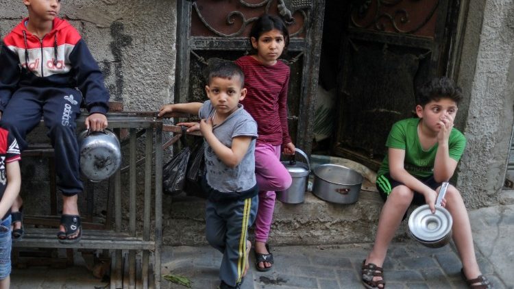 Niños palestinos en la Franja de Gaza, esperando que lleguen los alimentos.