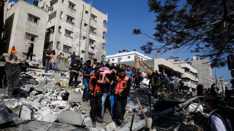 Rescue workers assist victims amid the rubble left by an Israeli air strike on Gaza City