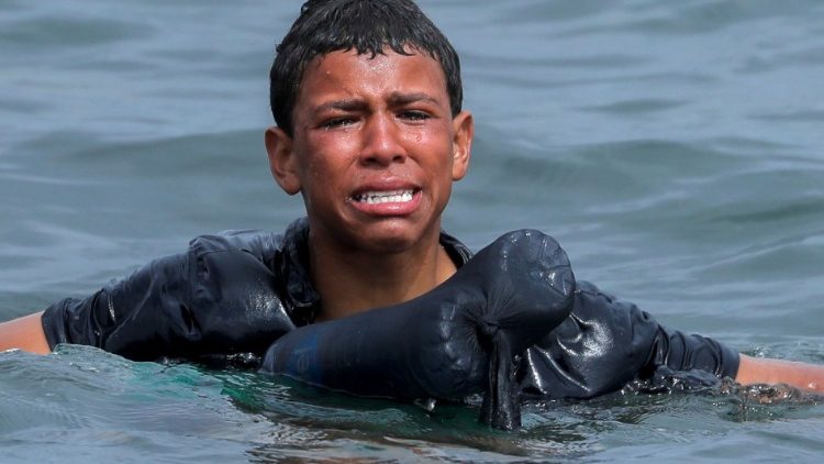 Jovem marroquino chora ao nadar usando garrafas como bóia, próximo à cerca entre a fronteira hispano-marroquina. REUTERS / Jon Nazca
