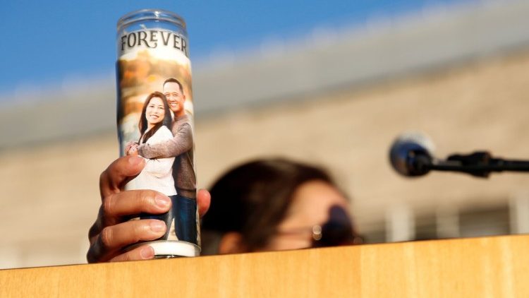 Esposa de Paul Delacruz Megia segura uma vela com uma foto dos dois enquanto fala durante uma vigília de oração pelas vítimas de um tiroteio em um pátio ferroviário em San Jose, Califórnia, EUA, 27 de maio de 2021 . REUTERS / Brittany Hosea-Small