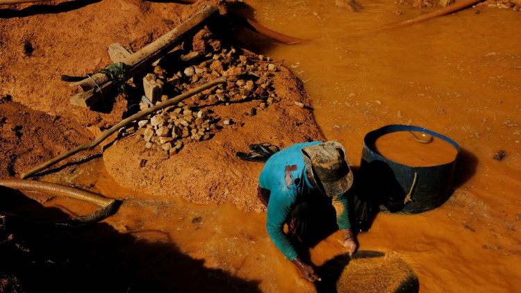 A gold miner uses a basin and mercury to pan for gold at a wildcat gold mine,  at a deforested area of the Amazon rainforest