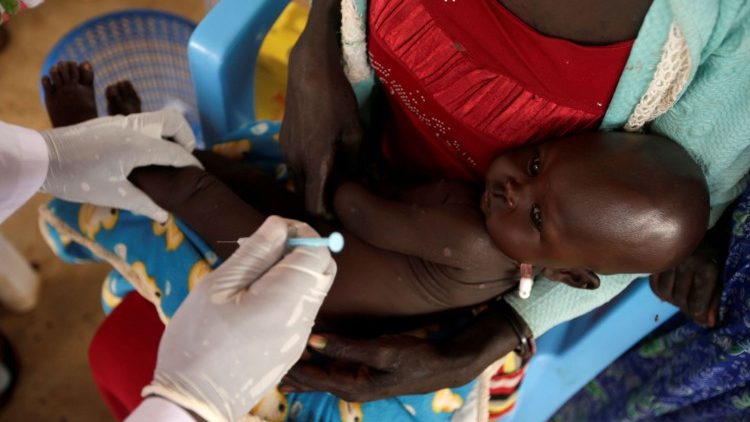 A South Sudanese refugee child receives a vaccination jab