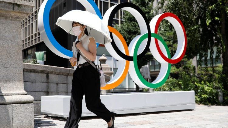 Una mujer camina frente al monumento de los anillos olímpicos antes de los Juegos Olímpicos de Tokio 2020 en Tokio.