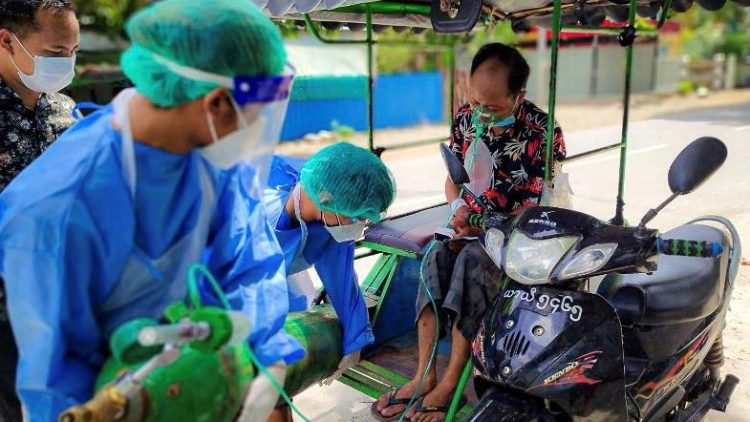 Volunteers help a Covid-19 patient with oxygen in Kale town,  Myanmar.