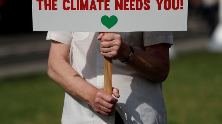 A sign reads "The climate needs you!"