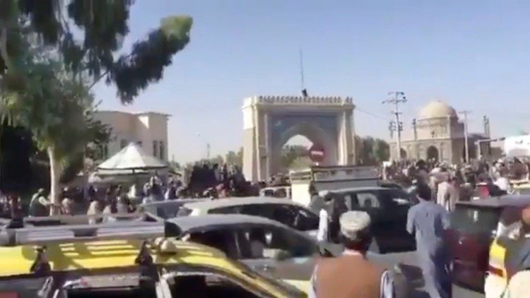People gather near Kandahar city gate in the Eid Gah Darwaza area as Taliban forces raise their flag