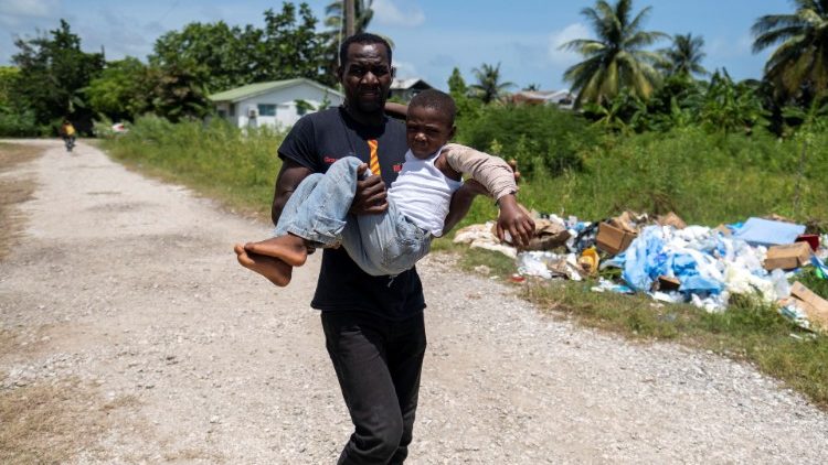 Haitiano carrega menino ferido após o terremoto de 7,2 que abalou o sul da ilha caribenha no sábado