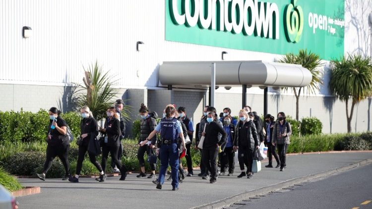 Un oficial de policía conduce a los empleados de la tienda lejos de la escena de un ataque llevado a cabo por un hombre que hirió a múltiples personas en un centro comercial en Auckland, Nueva Zelanda, 3 de septiembre de 2021.