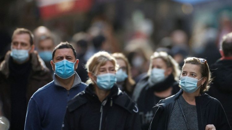 People wearing face masks are seen on a Paris street