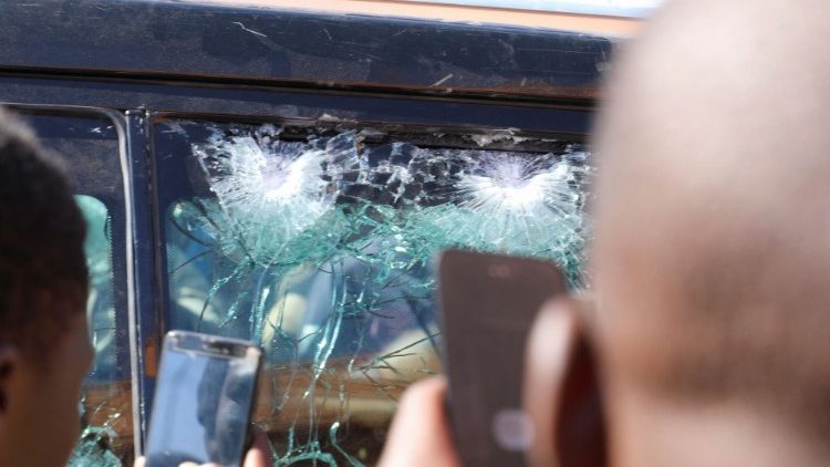 Onlookers take photographs of bullet holes in a vehicle belonging to President Roch Kabore