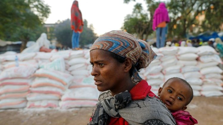 A displaced woman and her child await food aid in Tigray region's Shire town in Ethiopia. 