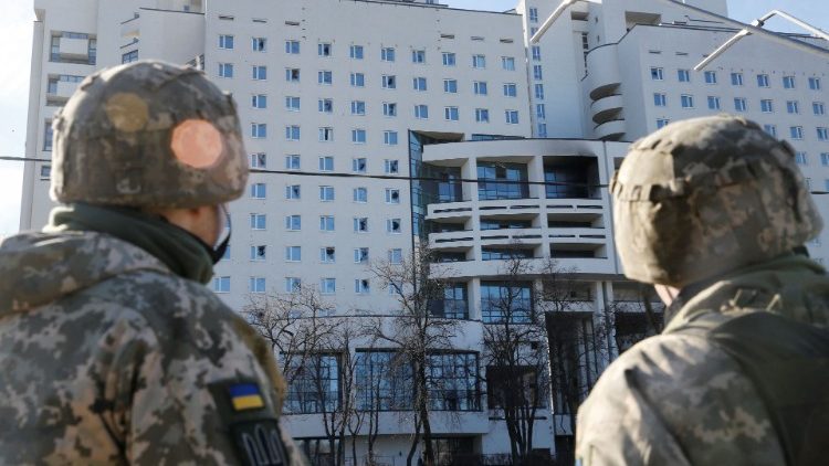 Des soldats ukrainiens devant un immeuble touché par des frappes russes à Kiev, le 26 février 2022