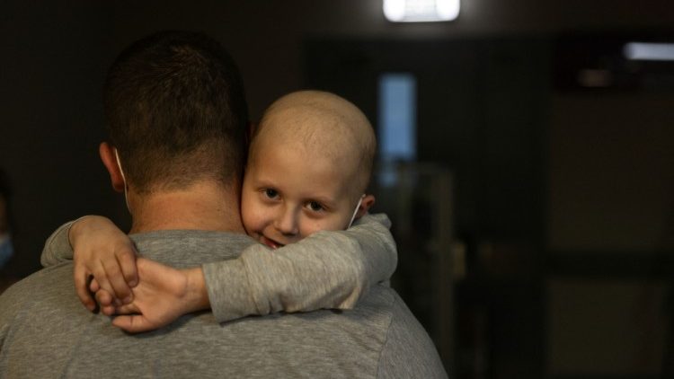 Um paciente infantil, cujo tratamento de leucemia está em andamento, abraça seu pai no Hospital Infantil de Okhmadet, em Kiev (Foto: Umit Bektas)