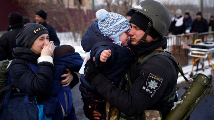 Irpin (Ucrania). Un niño llora en los brazos de su padre soldado que se va 