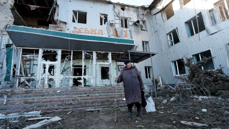 Žena stoji pred razrušenom bolnicom u Volnovakhi, u Donjetsku
