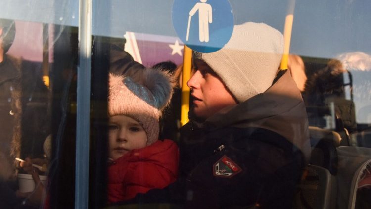 Lágrima dos olhos de pessoa com uma criança em ônibus para refugiados que fogem da invasão russa da Ucrânia, em Lviv, Ucrânia, em 13 de março de 2022. Foto tirada através de uma janela de vidro. REUTERS/Pavlo Palamarchuk