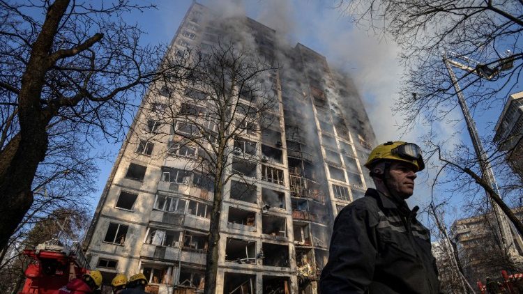 Firefighters work to put out a fire in a residential apartment building after it was hit by shelling in Kyiv