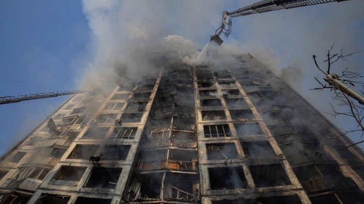 Kyjivo gaisrininkai mėgina užgesinti ugnį bombarduotame daugiaaukštyje