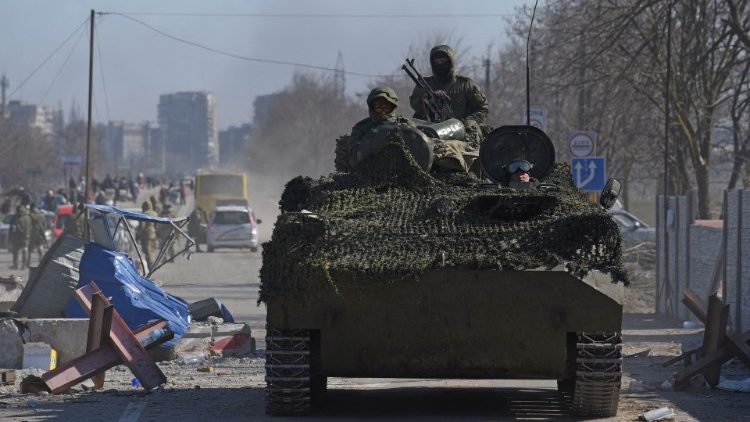 Miembros de las tropas prorrusas con uniformes sin insignias conducen un vehículo blindado durante el conflicto entre Ucrania y Rusia en la asediada ciudad portuaria del sur de Mariúpol