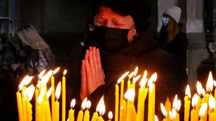 Mulher reza na Igreja Santos Pedro e Paulo Garrison em meio à invasão russa da Ucrânia, em Lviv, Ucrânia, 20 de março de 2022. (REUTERS/Zohra Bensemra)