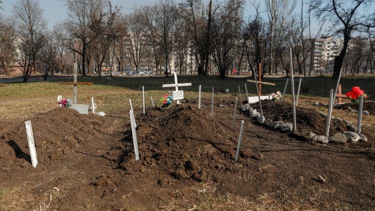 Túmulos de moradores mortos por bombardeios durante o conflito Ucrânia-Rússia são vistos em um pátio, no porto sul sitiado de Mariupol, na Ucrânia, em 23 de março de 2022. REUTERS / Alexander Ermochenko