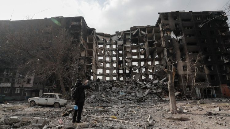 Um morador local caminha perto de um prédio de apartamentos destruído durante o conflito Ucrânia-Rússia na cidade portuária sitiada de Mariupol, Ucrânia, em 25 de março de 2022 REUTERS/Alexander Ermochenko