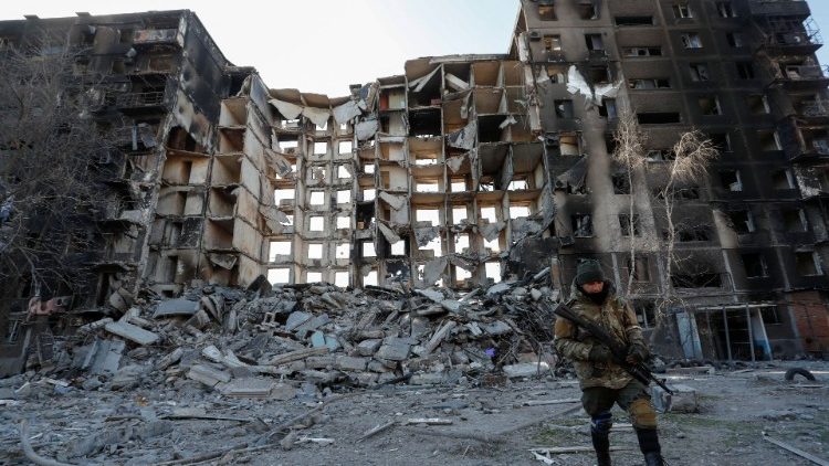 Combatente pró-Rússia caminha próximo a prédio destruído em Mariupol (REUTERS/Alexander Ermochenko)
