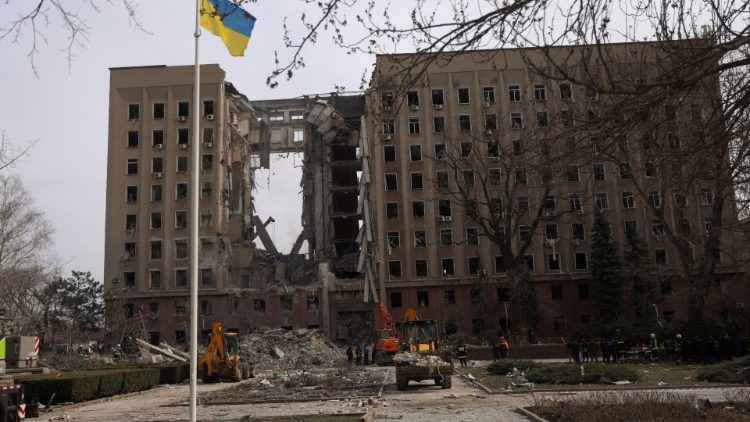 Pessoas e equipes de resgate se reúnem perto de uma parte destruída de um prédio administrativo do governo ucraniano após um bombardeio, enquanto a invasão russa da Ucrânia continua, em Mykolaiv, Ucrânia, 29 de março de 2022. REUTERS/Nacho Doce