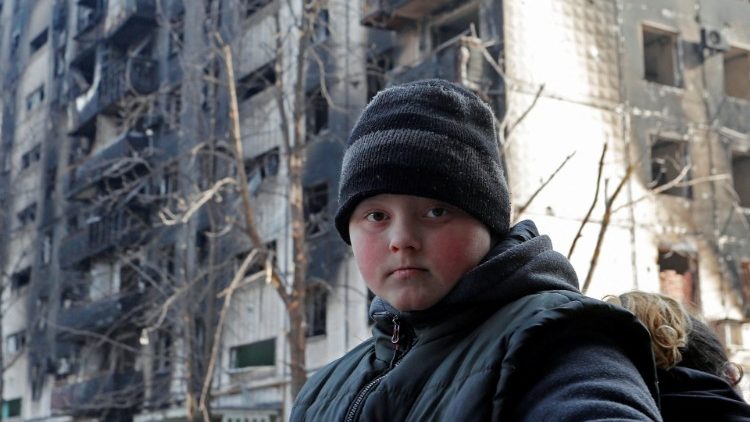 Un niño es visto fuera de un edificio de apartamentos dañado durante el conflicto entre Ucrania y Rusia en la sitiada ciudad portuaria del sur de Mariúpol, Ucrania 31 de marzo de 2022. 