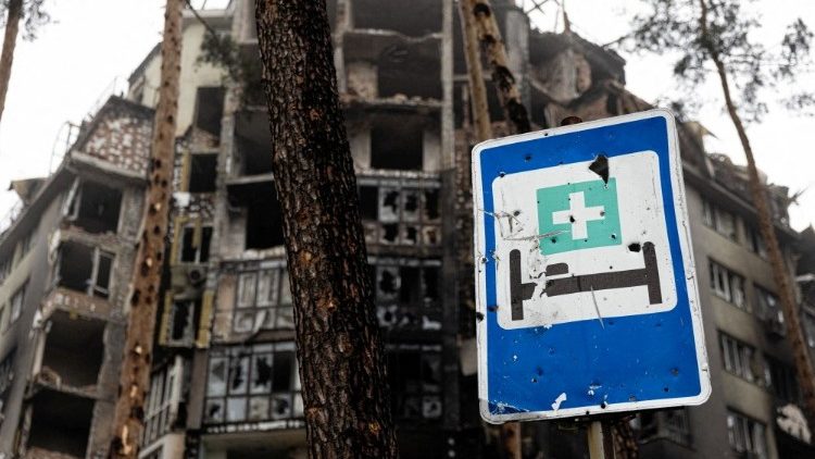 Ein beschädigtes Krankenhaus-Hinweisschild vor einem zerstörten Gebäude in Irpin 