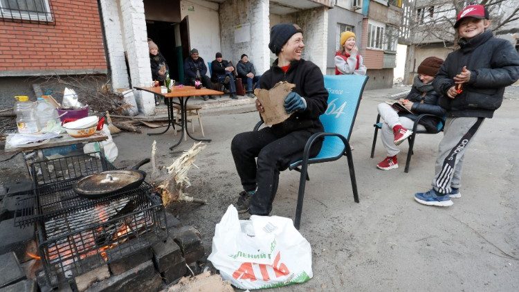 A moradora local Yekaterina Lanina, 34, com seus filhos e vizinhos se reúnem do lado de fora de um prédio de apartamentos durante o conflito Ucrânia-Rússia na cidade portuária de Mariupol, no sul da Ucrânia, em 3 de abril de 2022. REUTERS/Alexander Ermochenko