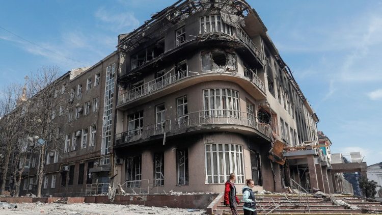Moradores caminham perto de um prédio destruído durante o conflito Ucrânia-Rússia, na cidade portuária de Mariupol, no sul da Ucrânia, em 10 de abril de 2022 REUTERS/Alexander Ermochenko