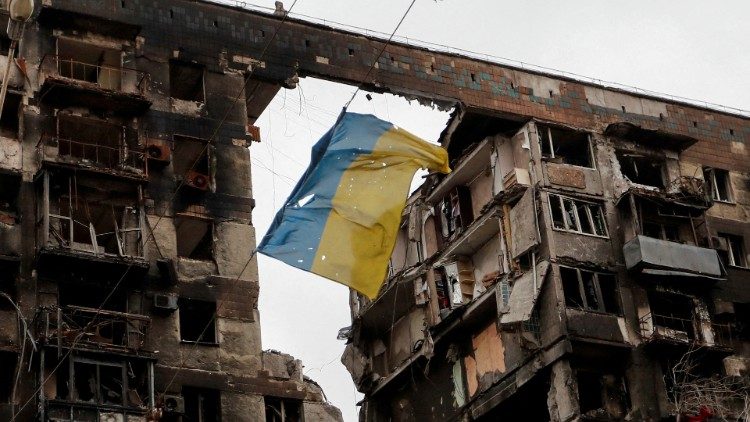 A view shows a Ukrainian flag near a destroyed building in Mariupol